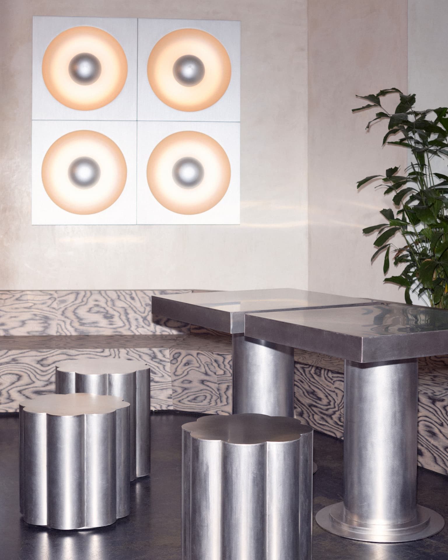 Seating area at DRAFT. Zürich with a four-panel glowing circle artwork